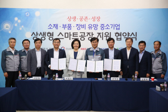지난달 30일 경기 김포에 위치한 에스비비테크에서 열린 '상생형 스마트공장 지원 협약식'에서 서승원 중기중앙회 부회장(왼쪽 네번째부터), 박영선 중기부 장관, 류재완 SBB대표, 김종호 삼성전자 사장, 윤부근 삼성전자 부회장 등 주요 인사들이 협약식을 마치고 기념촬영을 하고 있다.  중기부 제공